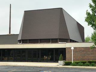 White Interlock IB Membrane aluminum roof on a brown home with a metal roof among urban buildings, Chicago Heights, Illinois