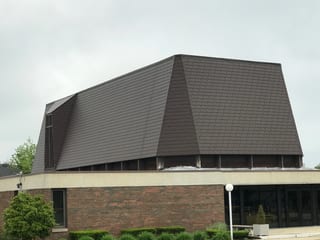 White Interlock IB Membrane aluminum roof on a white two-storey home with a metal roof and a grey sky, Chicago Heights, Illinois