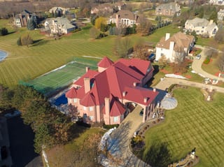 Tile Red Interlock Tile aluminum roof on a red two-storey colonial home with dormers in a suburban, South Barrington, Illinois