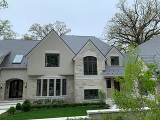 Musket Grey Interlock Slate aluminum roof on a cream-coloured two-storey home with stone accents among, Long Grove, Illinois