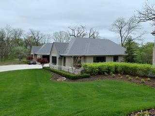 Musket Grey Interlock Slate aluminum roof on a beige ranch home with a grey metal roof in a forested, Long Grove, Illinois