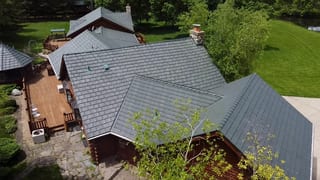 Hunter Green Interlock Shake aluminum roof on a brown ranch home with a green roof in a forested rural, Harvard, Illinois