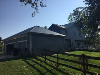 Deep Charcoal Interlock Slate aluminum roof on a grey home with dormers in a wooded rural area, Plano, Illinois