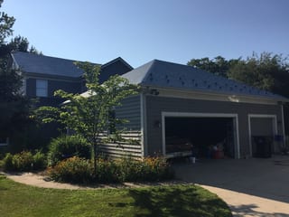 Deep Charcoal Interlock Slate aluminum roof being installed on a grey modern home with a metal roof under construction, Plano, Illinois
