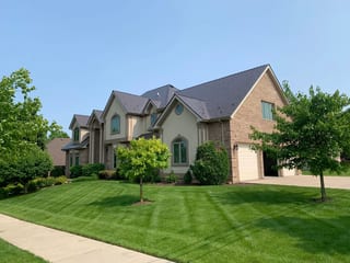 Tudor Brown Interlock Slate aluminum roof on a Tudor brown single-family home with dormers in a lush, Roselle, Illinois