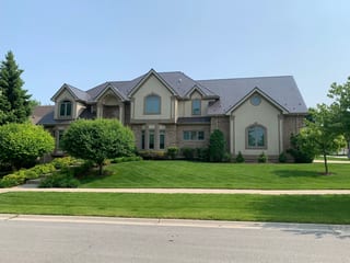 Tudor Brown Interlock Slate aluminum roof on a Tudor home with brown brick and cream siding in a, Roselle, Illinois