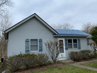 Royal Blue Interlock Slate aluminum roof on a two-storey home with a grey roof in a suburban setting, Woodstock, Illinois