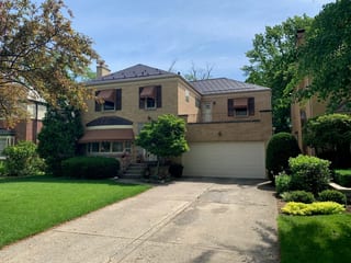 Colonial Brown Interlock Slate aluminum roof on a brown two-storey home with dormers among tall trees, River Forest, Illinois