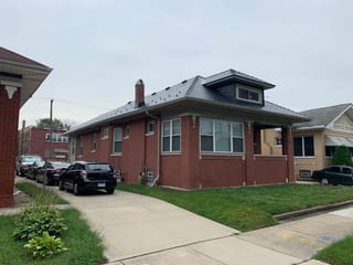 Black Interlock Slate aluminum roof on a red brick house with a black metal roof in a residential, Chicago, Illinois