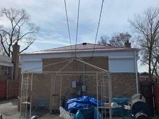 Tile Red Interlock Slate aluminum roof on a tan brick single-family home with a metal roof, Calumet Park, Illinois