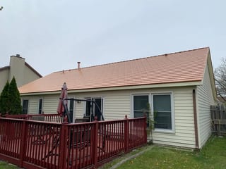 Copper Penny Interlock Cedar Shingle aluminum roof on a ranch home with beige siding under a cloudy sky, Bolingbrook, Illinois