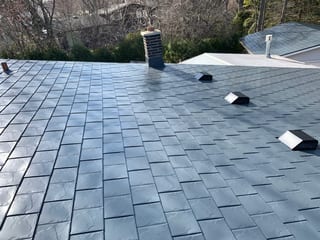 Deep Charcoal Interlock Slate aluminum roof on a modern home with a metal roof in a forested urban area, Waukegan, Illinois