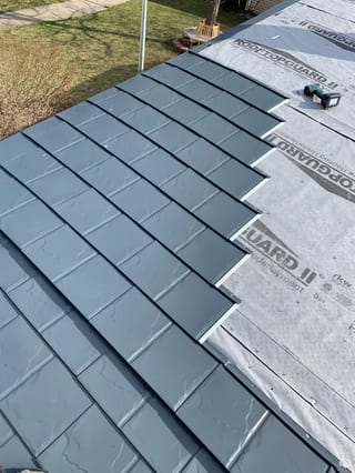 Deep Charcoal Interlock Slate aluminum roof being installed on a two-storey home with dormers in a suburban setting, Waukegan, Illinois