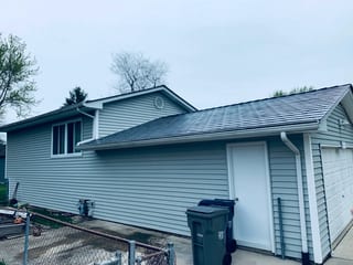 Deep Charcoal Interlock Slate aluminum roof on a two-storey home with a metal roof and white trim in a, Elgin, Illinois