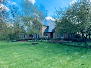 Deep Charcoal Interlock Slate aluminum roof on a brick two-storey colonial home among trees in Crystal Lake, Crystal Lake, Illinois