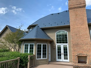 Deep Charcoal Interlock Slate aluminum roof on a tan colonial home with a metal roof and a tall brick, Crystal Lake, Illinois