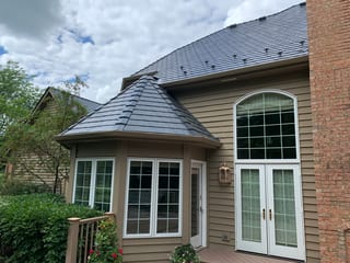 Deep Charcoal Interlock Slate aluminum roof being installed on a tan house with a metal roof and a deck in Crystal Lake,, Crystal Lake, Illinois