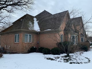 Before: a worn out wood shake roof on the home, Crystal Lake, Illinois, ahead of a Deep Charcoal Interlock Slate aluminum roof