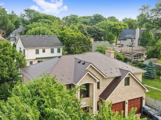 Colonial Brown Interlock Slate aluminum roof on a colonial style home with brown garage doors among trees, Calredon Hills, Illinois