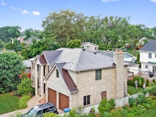 Colonial Brown Interlock Slate aluminum roof on a colonial home with a metal roof in a forested area, Calredon Hills, Illinois