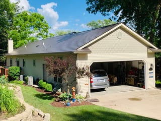 Tudor Brown Interlock Cedar Shingle aluminum roof on a cream-coloured ranch home with a grey roof among tall, Algonquin, Illinois