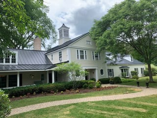 Black Interlock Standing Seam aluminum roof on a two-storey Colonial home with dormers in a forested, Lake Forest, Illinois