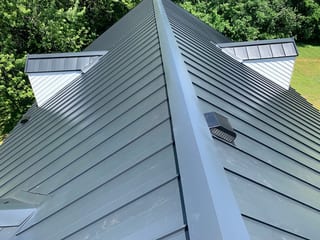 Black Interlock Standing Seam aluminum roof on a green metal roof on a single-family home in a forested, Lake Forest, Illinois
