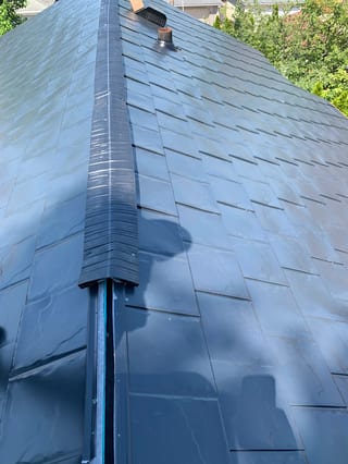 Black Interlock Slate aluminum roof being installed on a single-family home in a forested suburban setting, Oak Park, Illinois