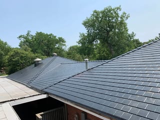 Black Interlock Slate aluminum roof on a red brick house with metal roof in a forested suburb, Flossmoor, Illinois
