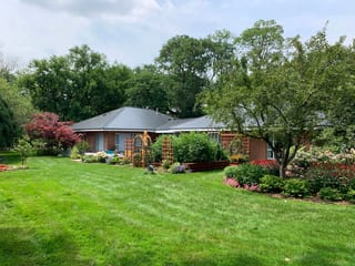 Black Interlock Slate aluminum roof on a red brick home with a grey metal roof surrounded by green, Flossmoor, Illinois