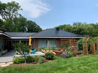 Black Interlock Slate aluminum roof on a red brick ranch home with a large front yard among trees, Flossmoor, Illinois