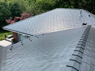 Black Interlock Slate aluminum roof on a single-family home with a metal roof in a forested setting, Flossmoor, Illinois