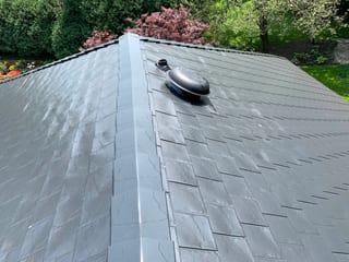 Black Interlock Slate aluminum roof on a two-storey home with black metal roof in a forested rural, Flossmoor, Illinois