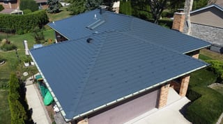Deep Charcoal Interlock Slate aluminum roof on a two-storey home with brick and stone accents in a, Westmont, Illinois