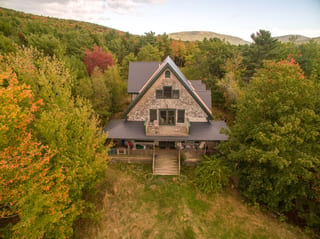 Deep Charcoal Interlock Cedar Shingle aluminum roof on a brown A-frame home in the woods, Bar Harbor, Maine