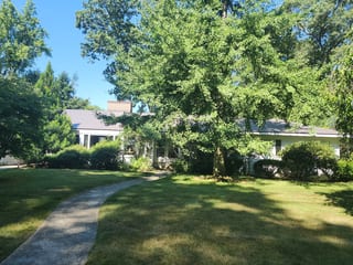 Weathered Interlock Slate aluminum roof being installed on a single-family home with a metal roof among trees, Longmeadow, Massachusetts