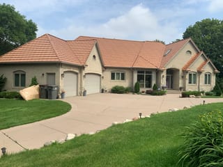 Aged Copper Interlock Shake aluminum roof on a beige one-storey home with a metal roof and a lawn, Eden Prairie, Minnesota