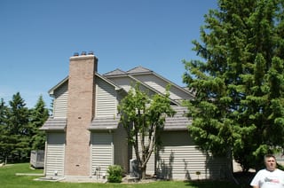 Weathered Interlock Shake aluminum roof on a beige single-family home with a metal roof among trees in, Mendota Heights, Minnesota