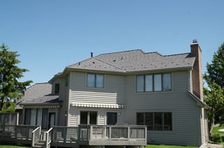 Weathered Interlock Shake aluminum roof on a two-storey Colonial home with a chimney in a forest, Mendota Heights, Minnesota