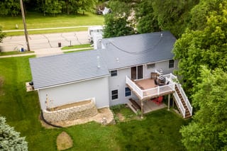 Deep Charcoal Interlock Slate aluminum roof on a two-storey home with dormers among tall green trees, Red Wing, Minnesota