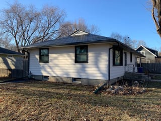 Black Interlock Slate aluminum roof on a white single-family home with a metal roof in a suburban, St Paul, Minnesota