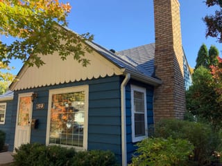 Deep Charcoal Interlock Slate aluminum roof on a blue home with a gable and chimney in a wooded suburban, Minneapolis, Minnesota