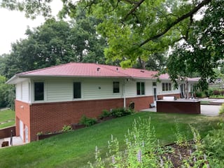 Tile Red Interlock Slate aluminum roof on a red-roofed ranch home in a forested suburban setting, Edina, Minnesota