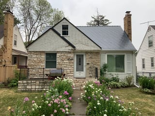 Deep Charcoal Interlock Slate aluminum roof on a white two-storey Cape Cod home with dormers in a suburban, Minneapolis, Minnesota