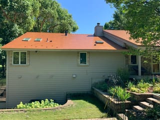 Copper Penny Interlock Slate aluminum roof on a ranch-style home with a copper penny metal roof in a lush, Shorewood, Minnesota