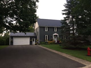 Black Interlock Slate aluminum roof on a black two-storey home with dormers and a metal roof, Fredericton, New Brunswick