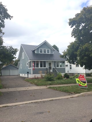 Black Interlock Slate aluminum roof on a grey two-storey Cape Cod with dormers in a suburban, Saint John, New Brunswick