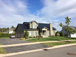 Black Interlock Slate aluminum roof on a beige Colonial home with a black metal roof and chimney, Fredericton, New Brunswick