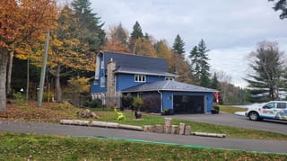 Black Interlock Slate aluminum roof on a blue two-storey home with a black metal roof in a, Utopia, New Brunswick