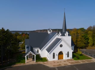 Deep Charcoal Interlock Slate aluminum roof on a white church with a metal roof among tall green trees, Rothesay, New Brunswick